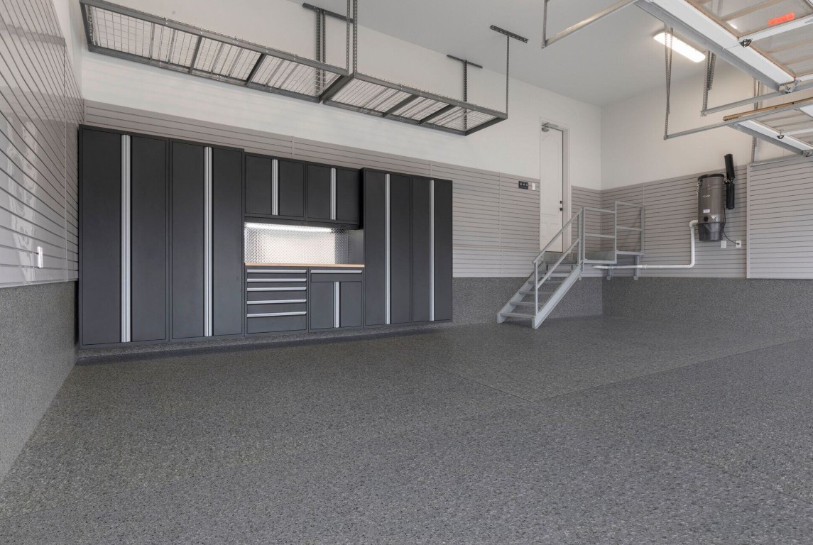 Finished epoxy coated garage floor with dark speckled finish in a large garage